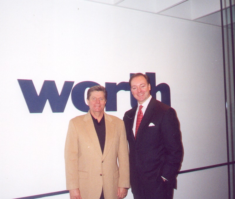 Billy Paul Smith and W. Randall Jones standing in front of a Warner logo at a 2001 Abuse of Process reception